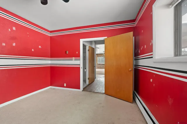 a kitchen with red and white wall under a large mirror
