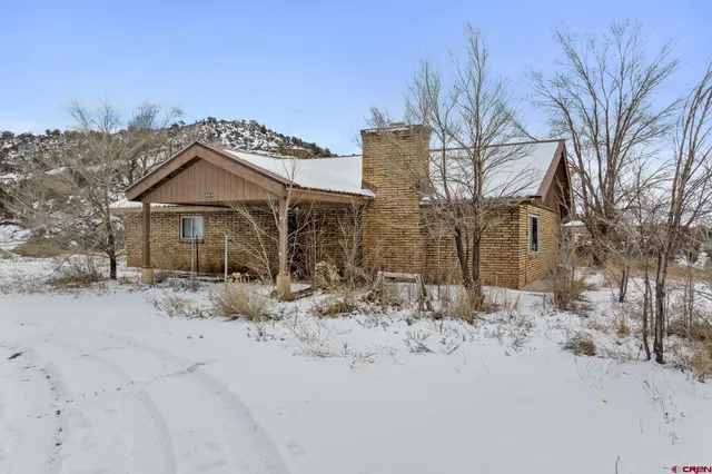 a front view of a house with a yard covered in snow