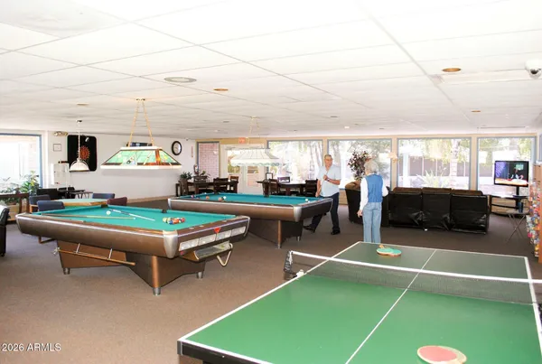 a room with pool table and windows