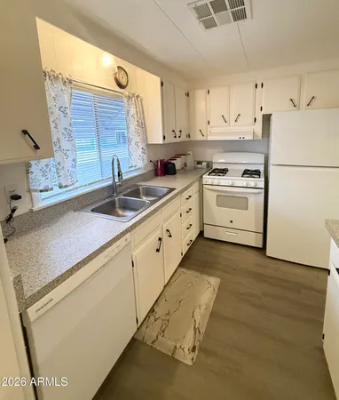 a kitchen with granite countertop white cabinets and white appliances