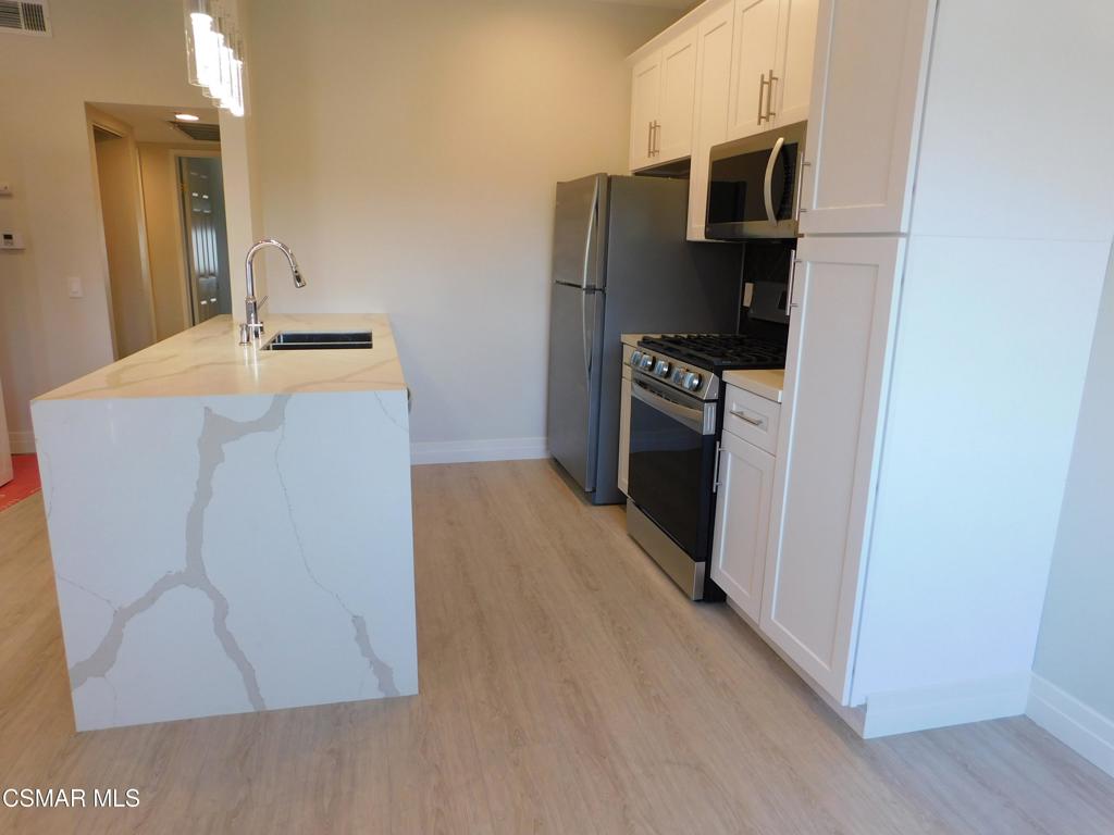 116 Maegan Place, Unit 11 Thousand Oaks, CA 91362 - Photo 2 of 35 a kitchen with stainless steel appliances a refrigerator stove and sink