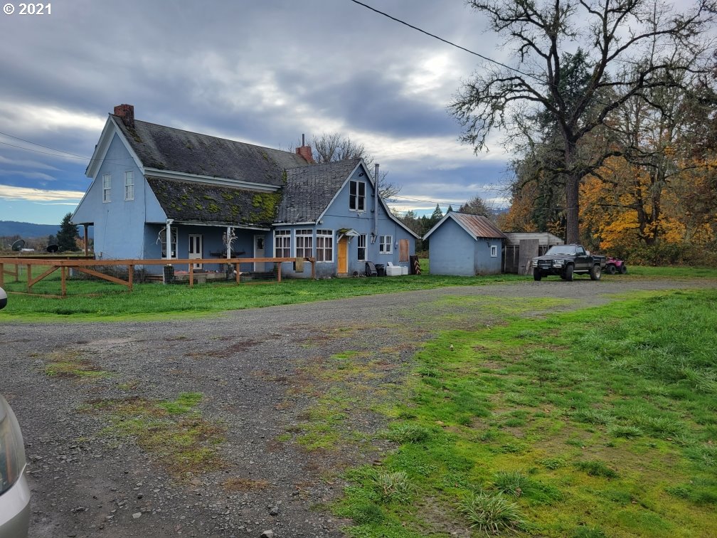1021 Upper Camas Road Camas Valley, OR 97416 - Photo 1 of 27 a view of a house next to a big yard with plants and large trees