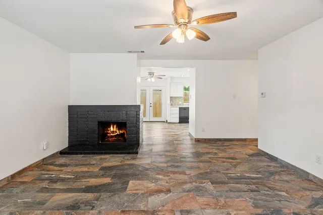an empty room with windows and a fireplace