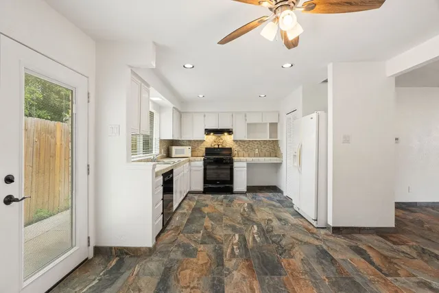 a kitchen with a refrigerator a stove top oven a sink and a window