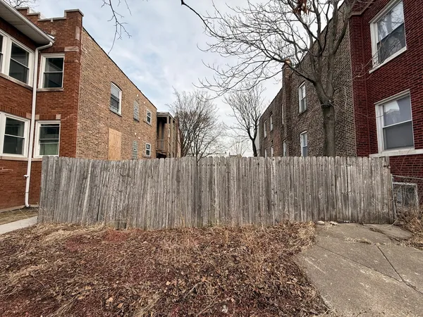 a view of a house with a wooden fence
