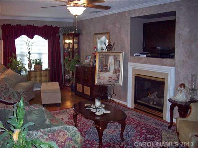 8027 Trotter Road Charlotte, NC 28216 - Photo 3 of 11 a living room with furniture a flat screen tv and a fireplace