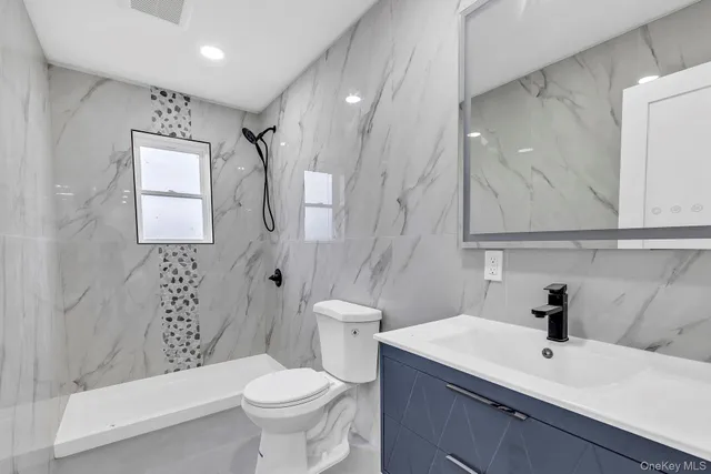 a bathroom with a sink a toilet and shower