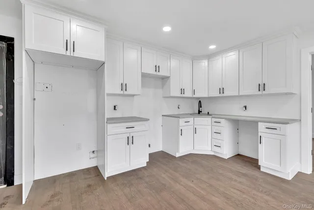 a kitchen with cabinets stainless steel appliances a sink and wooden floor