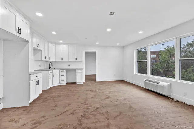 a large kitchen with stainless steel appliances granite countertop a large counter top that has a large window