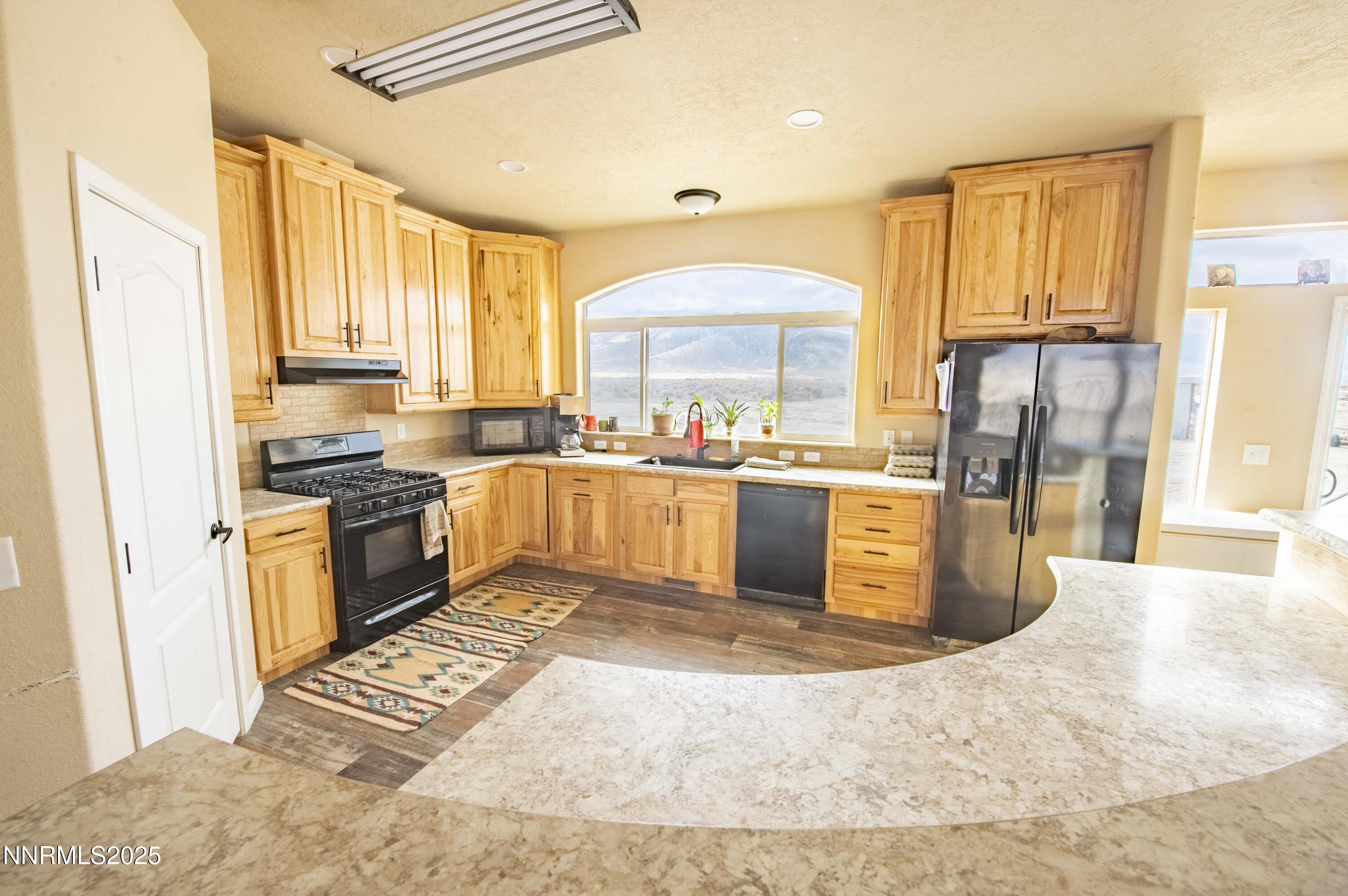 3139 Muddy Road Winnemucca, NV 89445 - Photo 13 of 46 a kitchen with a sink a counter top space cabinets and stainless steel appliances