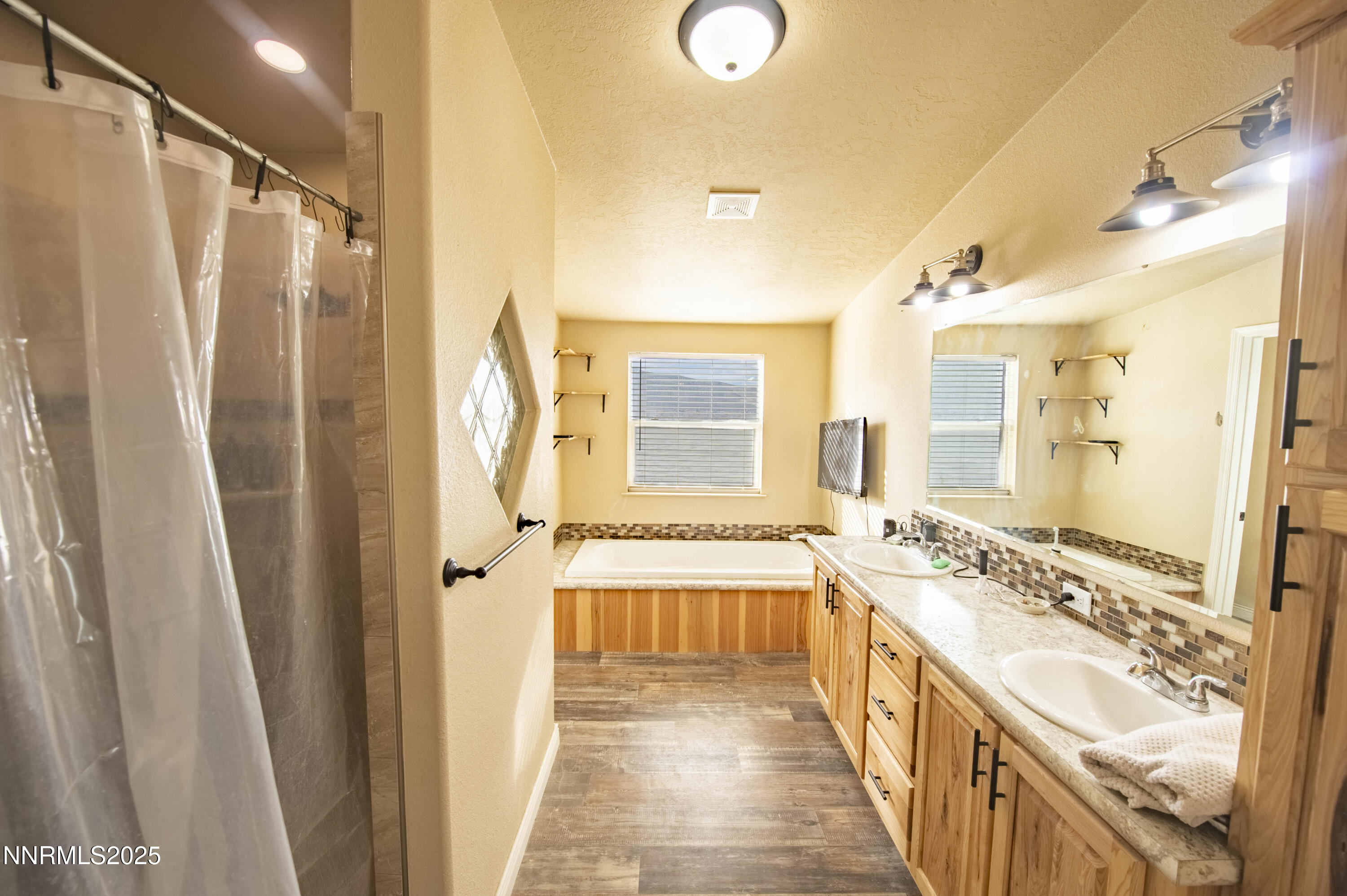 3139 Muddy Road Winnemucca, NV 89445 - Photo 30 of 46 a bathroom with a double vanity sink a mirror a bathtub and shower