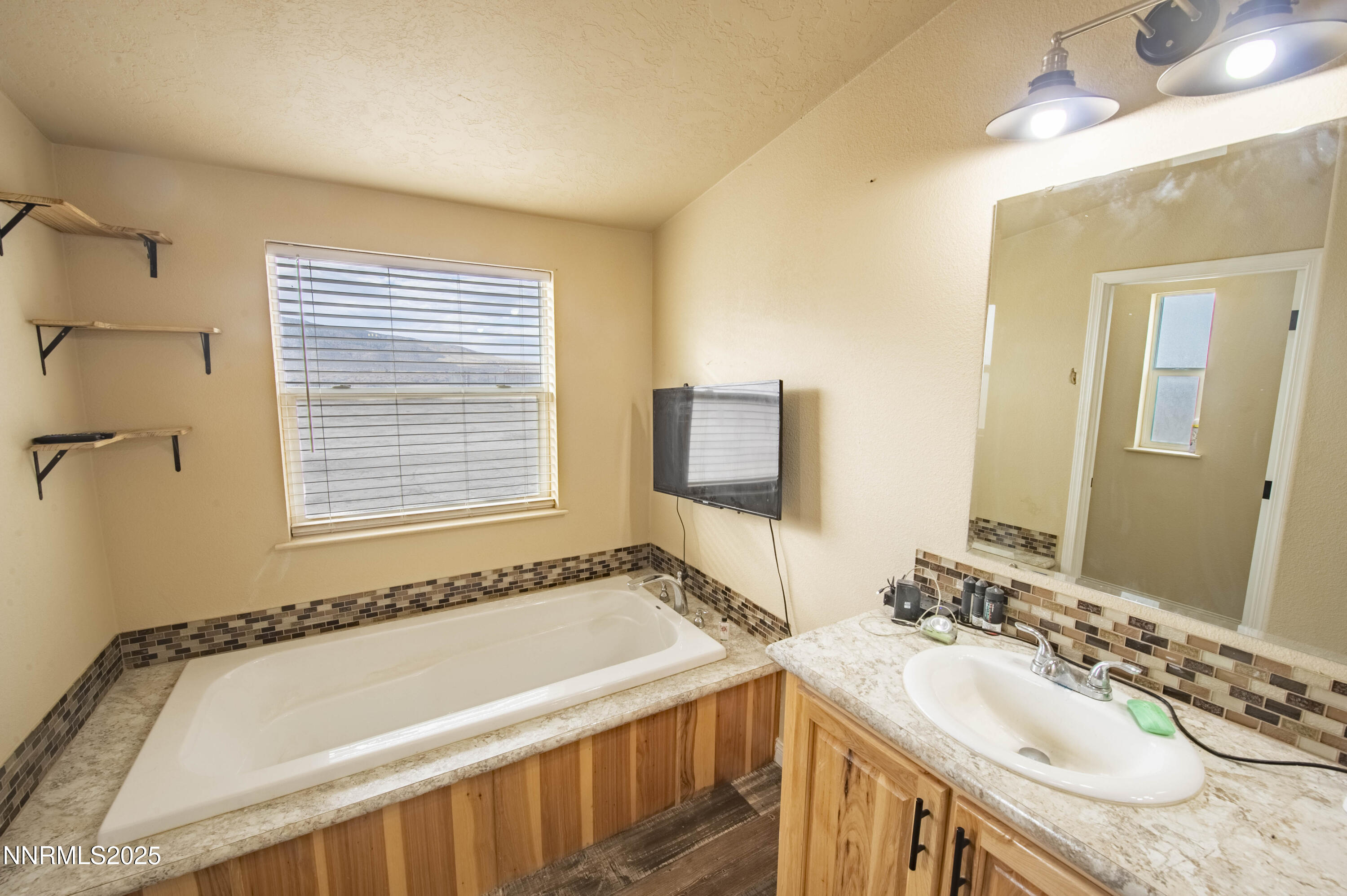 3139 Muddy Road Winnemucca, NV 89445 - Photo 31 of 46 a bathroom with a tub sink and mirror
