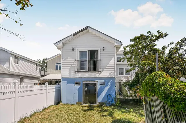 a view of a house with a small yard plants and large tree