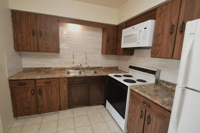 a kitchen with a stove sink and cabinets