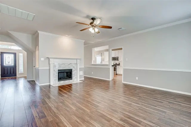 a living room with a fireplace and wooden floor