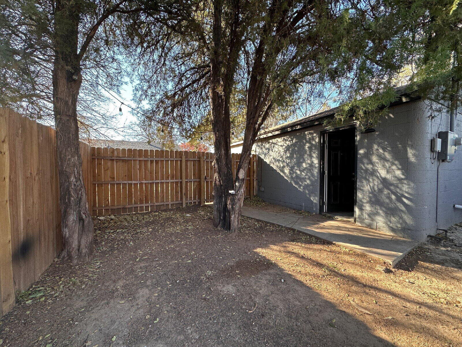 2622 32nd Street, Unit REAR Lubbock, TX 79410 - Photo 2 of 6 a view of a house with a large tree and wooden fence