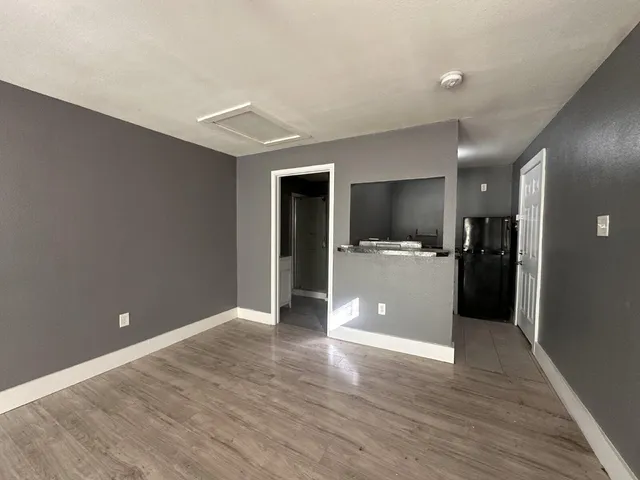 a view of a kitchen with a sink and an empty room