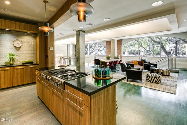 a kitchen with stainless steel appliances granite countertop a stove and a view of living room