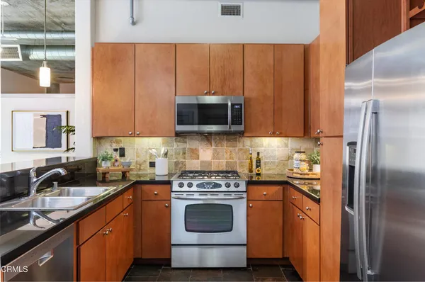 a kitchen with stainless steel appliances a stove a sink and a microwave