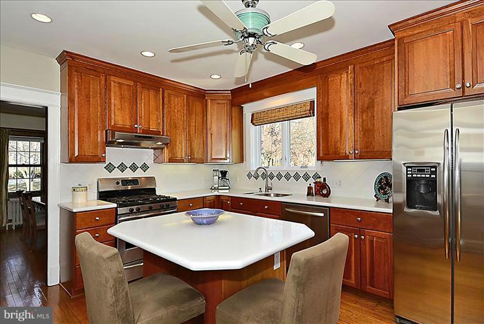 1914 Stratton Road Silver Spring, MD 20910 - Photo 5 of 13 a kitchen with stainless steel appliances granite countertop a sink a stove a refrigerator cabinets and chairs