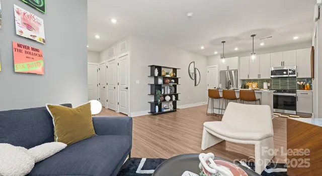 a kitchen with stainless steel appliances granite countertop a dining table chairs refrigerator and microwave