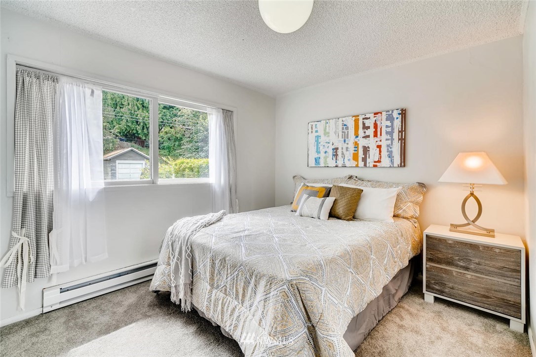 5633 Beach Drive Southwest Seattle, WA 98136 - Photo 7 of 25 a bedroom with a bed and wooden floor