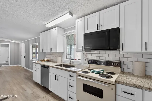 a kitchen with stainless steel appliances a sink a stove oven a sink dishwasher and cabinets