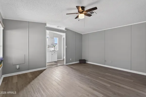 an empty room with wooden floor and windows