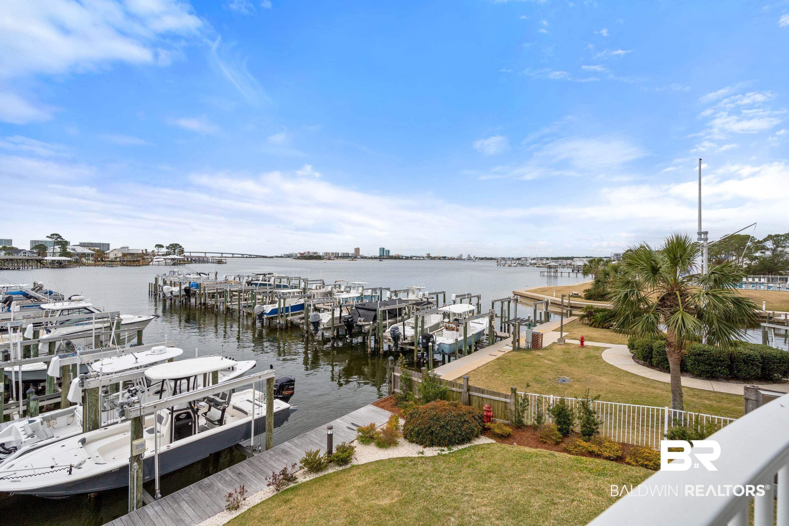 28250 Canal Road, Unit 101 Orange Beach, AL 36561 - Photo 25 of 34 View of dock featuring a water view, boat lift, fence, and a yard