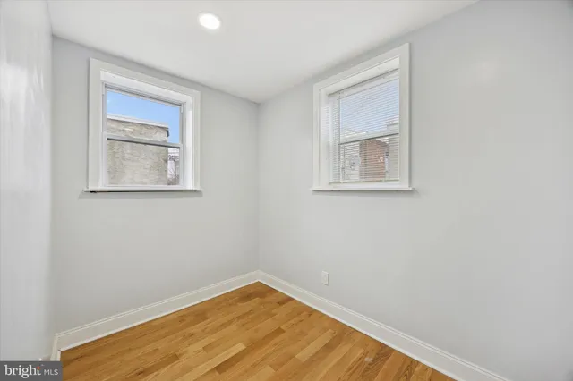 a view of empty room with wooden floor