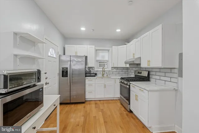 a kitchen with a sink stainless steel appliances and cabinets