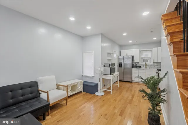 a living room with lots of furniture and kitchen view