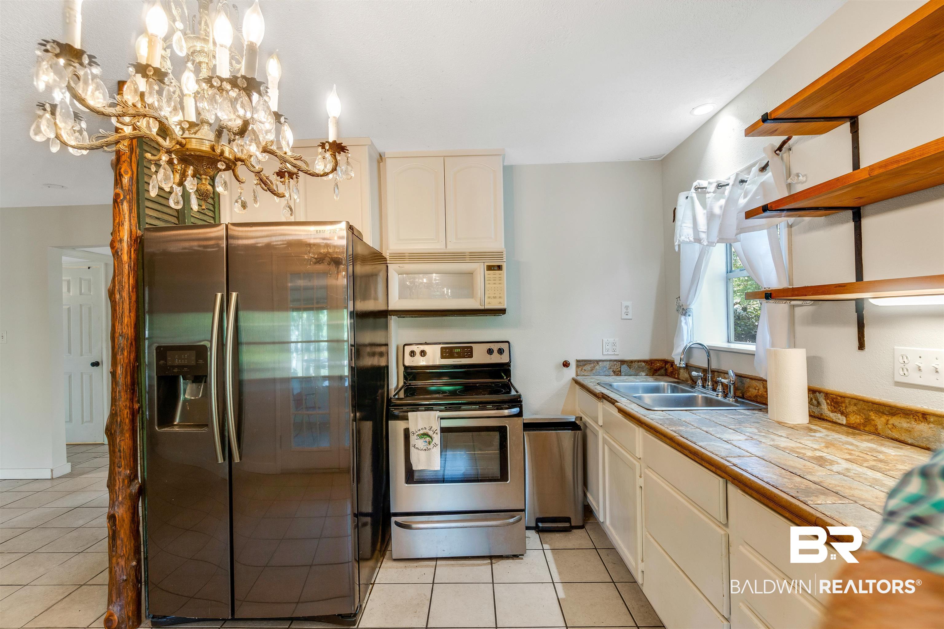 34341 Lost River Road Seminole, AL 36574 - Photo 10 of 36 Kitchen featuring stainless steel appliances, open shelves, light tile patterned floors, and tile countertops