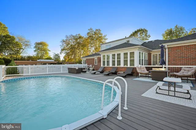 a view of a house with swimming pool and sitting area
