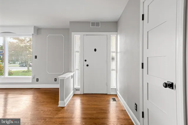 a view of a hallway with wooden floor and front door