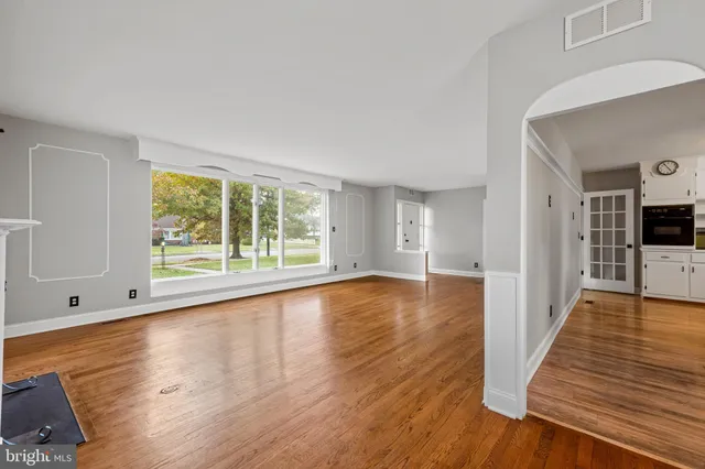 a view of a living room with wooden floor and a large window
