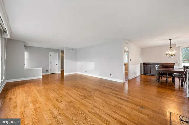 a view of empty room with wooden floor and furniture