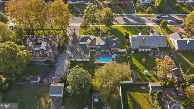 an aerial view of residential houses with outdoor space and trees