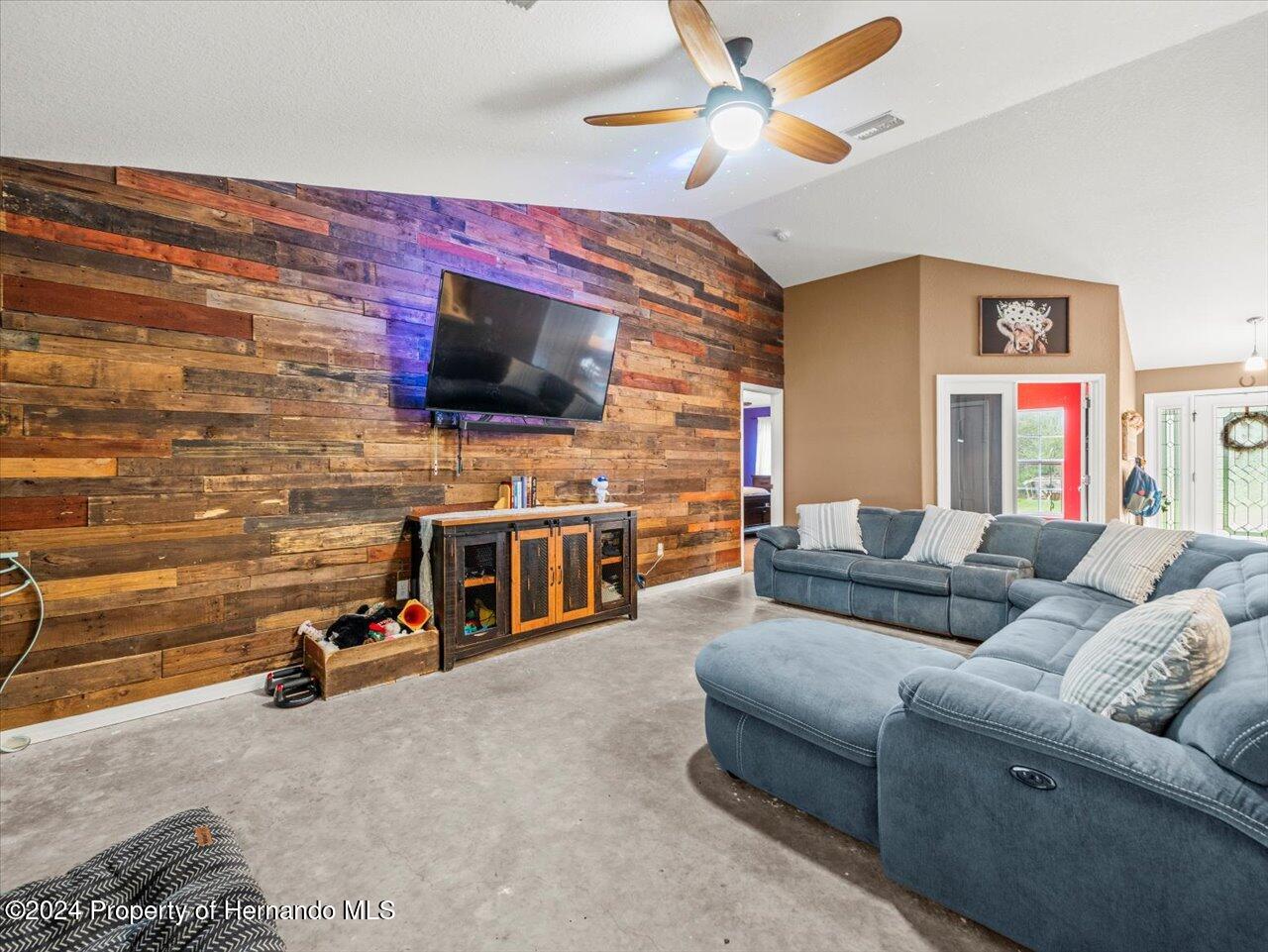 8108 Indian Trail Road Weeki Wachee, FL 34613 - Photo 19 of 59 a living room with furniture and a flat screen tv