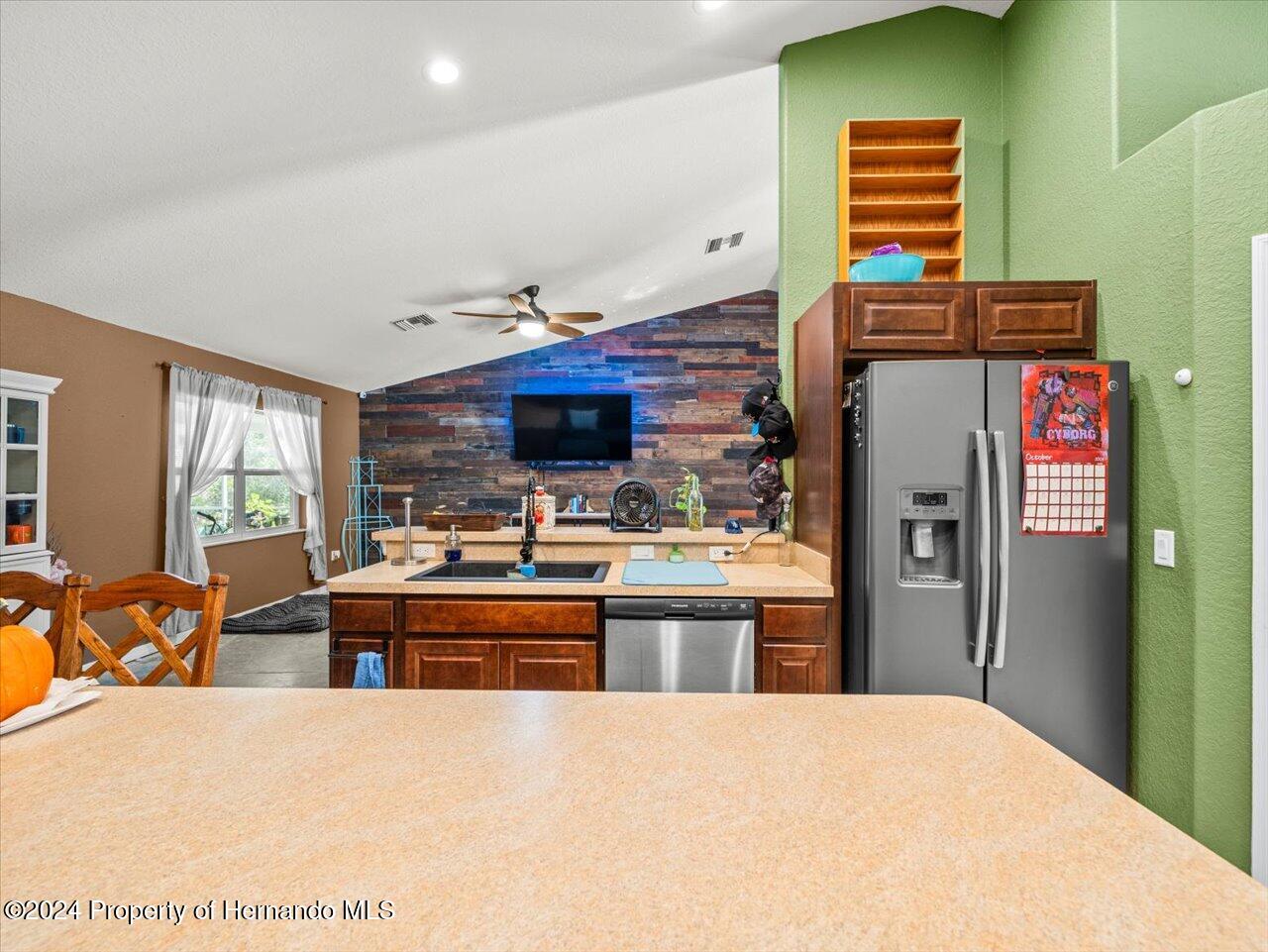8108 Indian Trail Road Weeki Wachee, FL 34613 - Photo 23 of 59 a kitchen with stainless steel appliances kitchen island granite countertop a refrigerator and a stove top oven