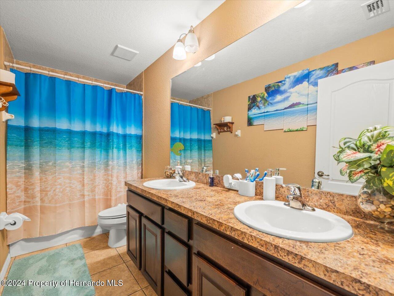 8108 Indian Trail Road Weeki Wachee, FL 34613 - Photo 41 of 59 a bathroom with a double vanity sink toilet and a mirror