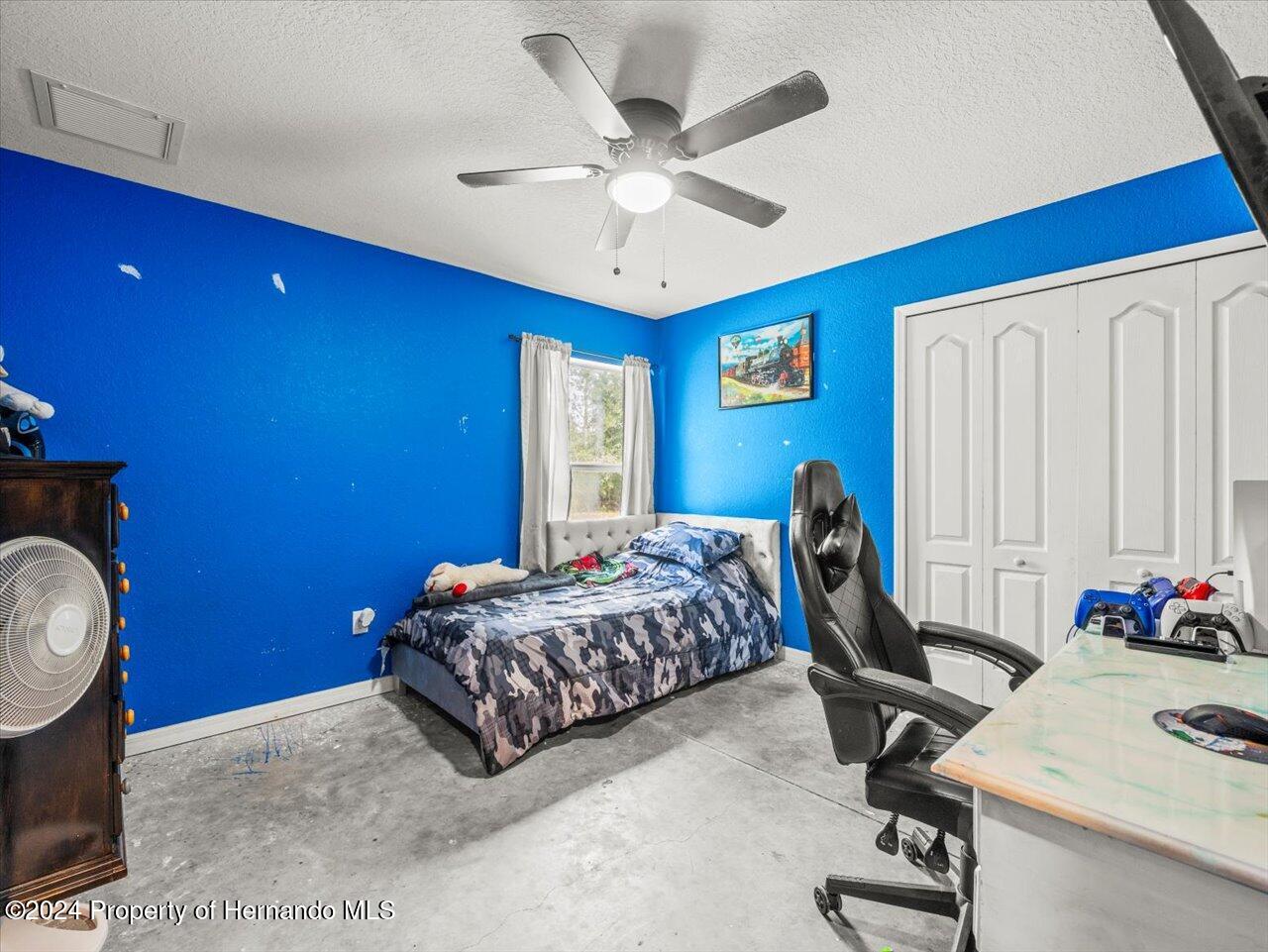 8108 Indian Trail Road Weeki Wachee, FL 34613 - Photo 42 of 59 a bedroom with a bed and a chandelier