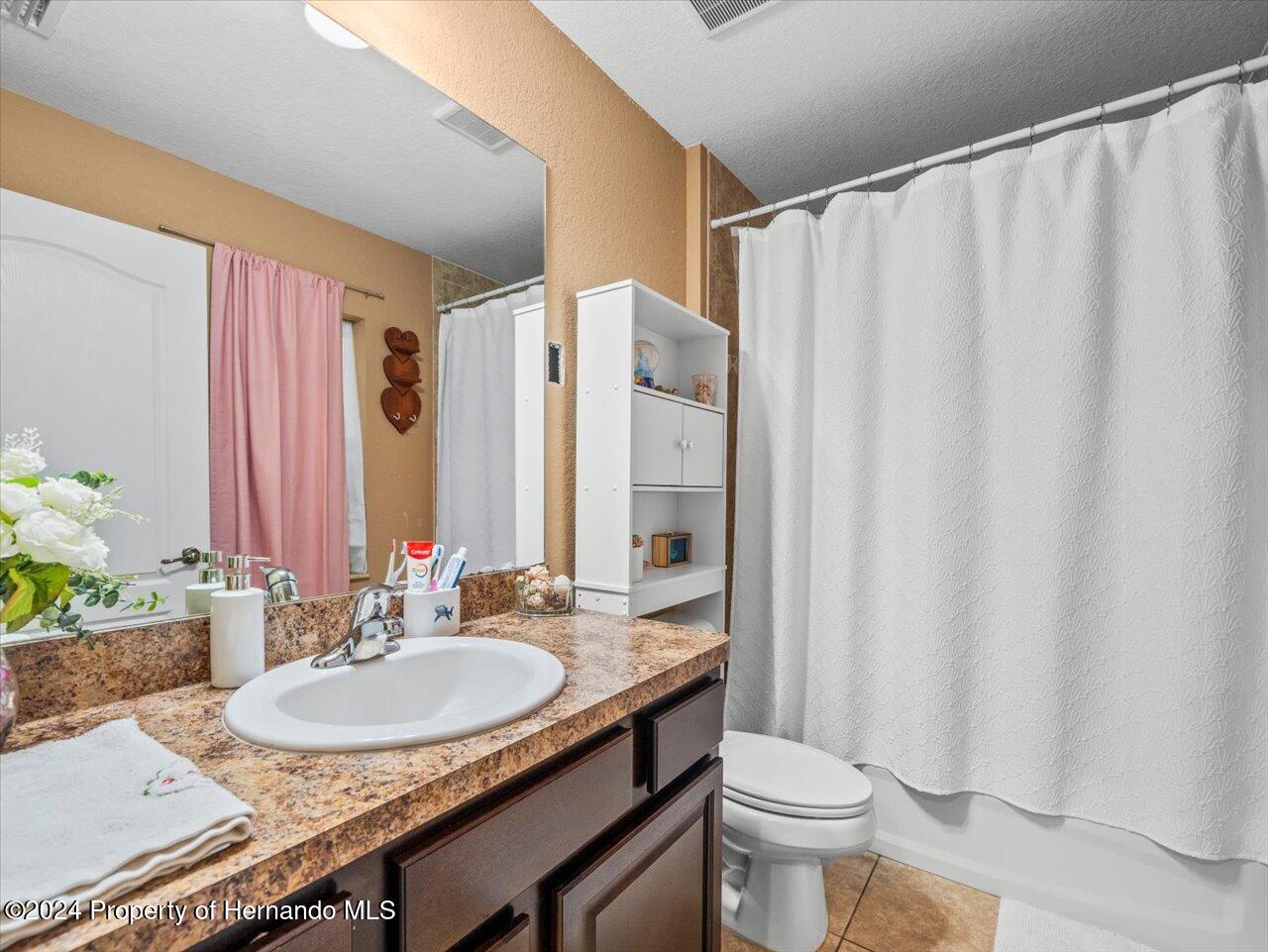 8108 Indian Trail Road Weeki Wachee, FL 34613 - Photo 46 of 59 a bathroom with a granite countertop sink and a mirror