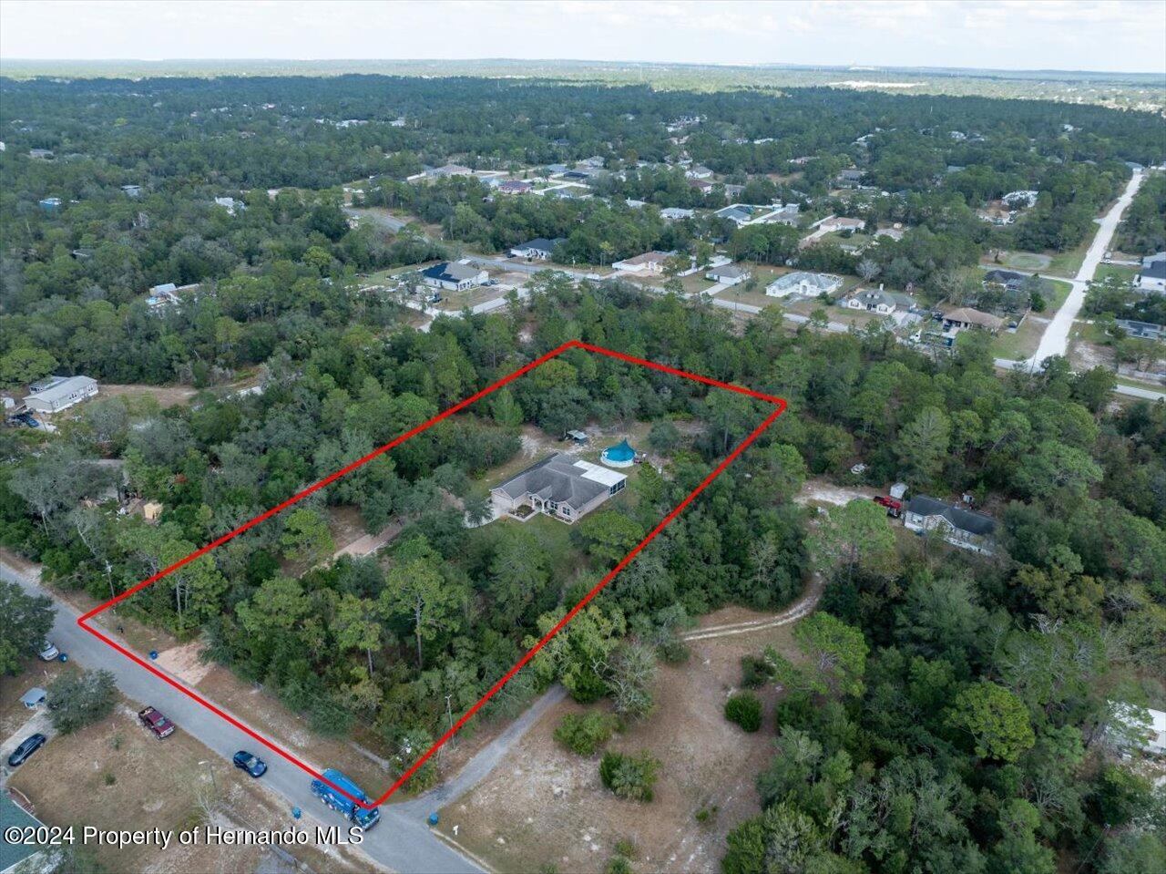 8108 Indian Trail Road Weeki Wachee, FL 34613 - Photo 8 of 59 an aerial view of green landscape with trees houses and mountain view