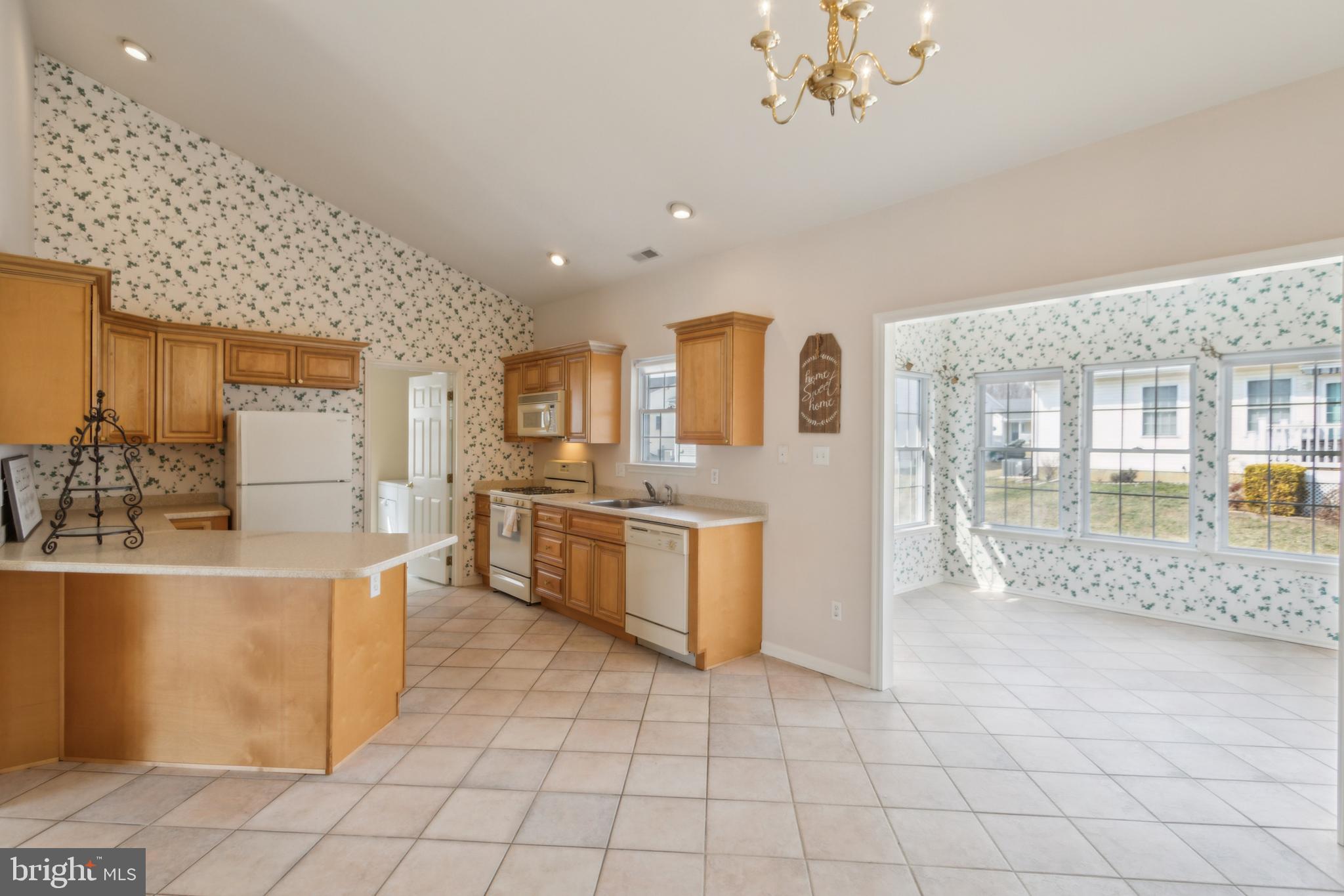 104 Trellis Lane Sewell, NJ 08080 - Photo 11 of 28 a large white kitchen with kitchen island granite countertop a stove a sink a refrigerator and white cabinets with wooden floor