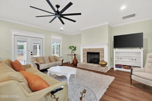 a living room with furniture kitchen view and a wooden floor