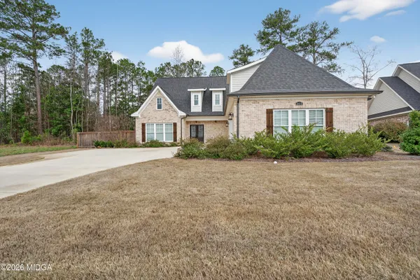 a front view of a house with a yard and green space