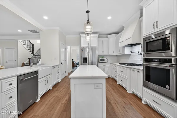 a kitchen with stainless steel appliances a stove microwave and a sink