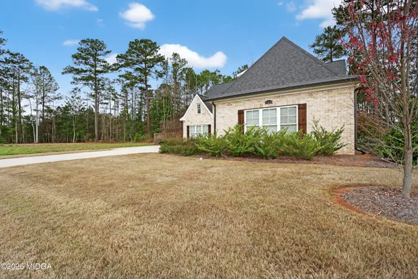 a front view of house with yard and trees around