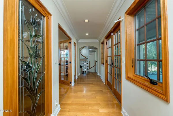a view of a hallway with wooden floor and furniture